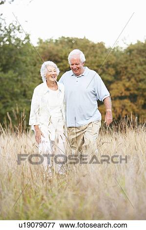 Stock Photo - Senior Couple Walking In Park. Fotosearch