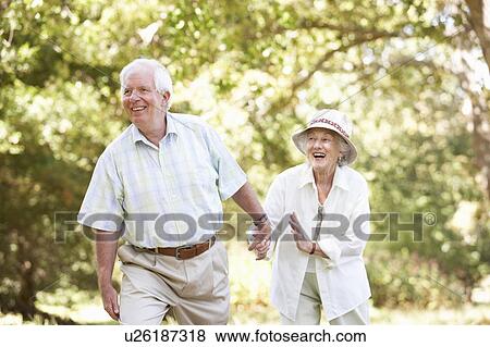 Senior Couple Walking In Park View Large Photo Image Stock Photo - Senior Couple Walking In Park. Fotosearch