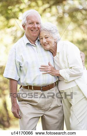 Stock Photograph - Senior Couple Walking In Park. Fotosearch