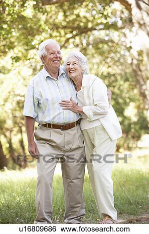 Stock Photograph - Senior Couple Walking In Park. Fotosearch