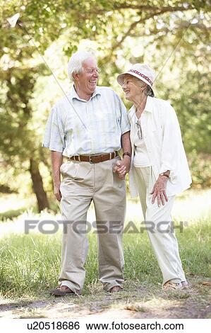 Stock Photograph - Senior Couple Walking In Park. Fotosearch
