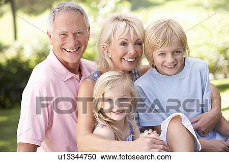 Senior couple with children posing in park View Large Photo Image Stock Image - Senior couple with children posing in park. Fotosearch