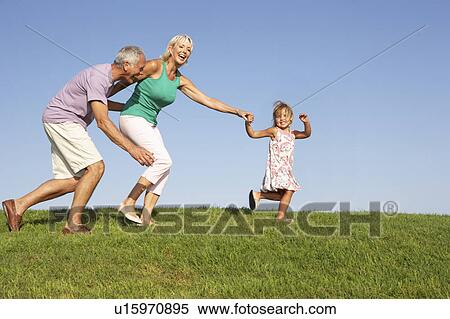 Senior couple, with granddaughter, running though field View Large Photo Image Stock Photography - Senior couple, with granddaughter, running though field. Fotosearch