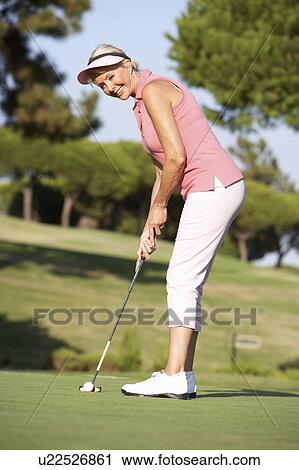 Senior Female Golfer On Golf Course Lining Up Putt On Green View Large Photo Image Stock Image - Senior Female Golfer On Golf Course Lining Up Putt On Green. Fotosearch