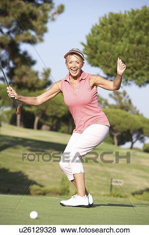 Senior Female Golfer On Golf Course Lining Up Putt On Green View Large Photo Image Stock Photo - Senior Female Golfer On Golf Course Lining Up Putt On Green. Fotosearch