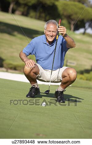 Senior Male Golfer On Golf Course Lining Up Putt On Green View Large Photo Image Stock Photo - Senior Male Golfer On Golf Course Lining Up Putt On Green. Fotosearch