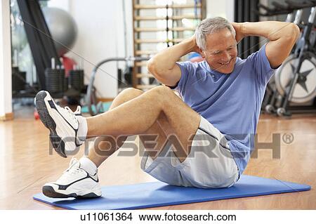 Picture - Senior Man Doing Sit Ups In Gym. Fotosearch