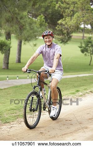 Senior man enjoying bike ride in park View Large Photo Image Stock Image - Senior man enjoying bike ride in park. Fotosearch