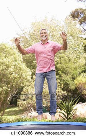 Senior Man Jumping On Trampoline In Garden View Large Photo Image Stock Photograph - Senior Man Jumping On Trampoline In Garden. Fotosearch