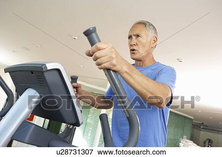 Stock Photo - Senior Man On Cross Trainer In Gym. Fotosearch