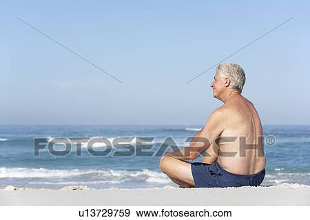 Senior Man On Holiday Sitting On Sandy Beach View Large Photo Image Stock Photo - Senior Man On Holiday Sitting On Sandy Beach. Fotosearch