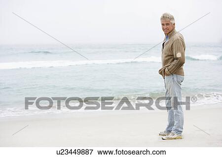 Senior Man On Holiday Standing On Winter Beach View Large Photo Image Stock Photo - Senior Man On Holiday Standing On Winter Beach. Fotosearch