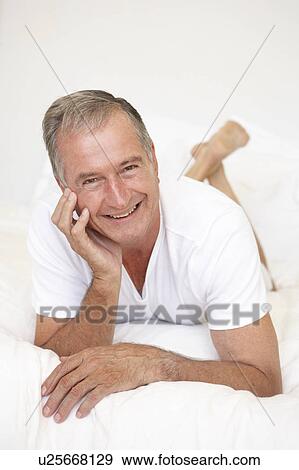 Stock Photo - Senior Man Relaxing On Bed. Fotosearch