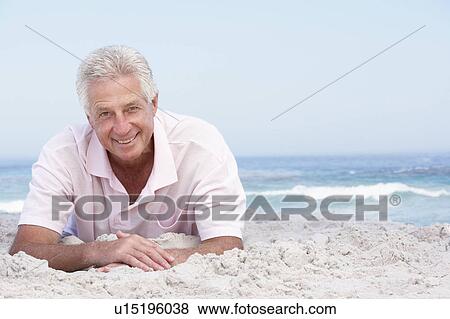 Stock Photo - Senior Man Relaxing On Sandy Beach. Fotosearch