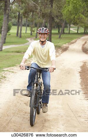 Senior man riding bicycle in park View Large Photo Image Stock Photograph - Senior man riding bicycle in park. Fotosearch