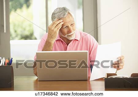 Stock Image - Senior Man Using Laptop At Home. Fotosearch