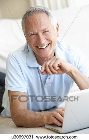 Stock Image - Senior man using laptop computer. Fotosearch