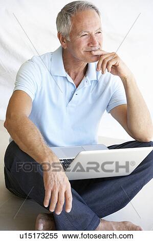 Senior man using laptop computer View Large Photo Image Stock Photography - Senior man using laptop computer. Fotosearch