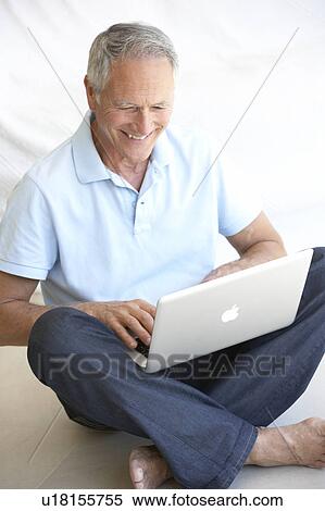 Senior man using laptop computer View Large Photo Image Stock Photography - Senior man using laptop computer. Fotosearch
