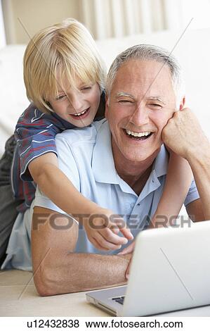 Stock Photo - Senior man with young boy using laptop computer. Fotosearch