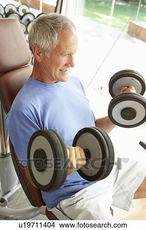 Picture - Senior Man Working With Weights In Gym. Fotosearch