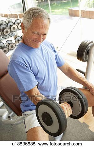 Stock Photography - Senior Man Working With Weights In Gym. Fotosearch