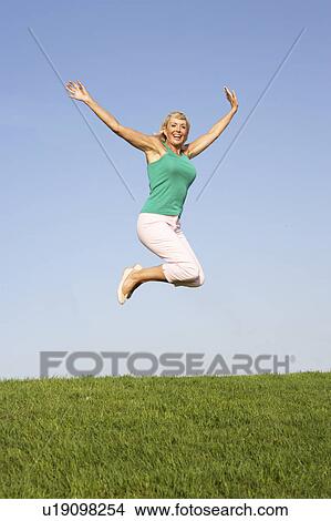 Picture - Senior woman jumping in air. Fotosearch