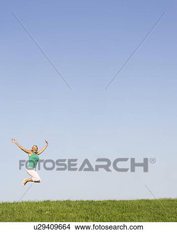 Picture - Senior woman jumping in air. Fotosearch