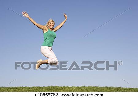 Stock Image - Senior woman jumping in air. Fotosearch