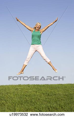 Stock Image - Senior woman jumping in air. Fotosearch