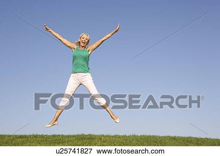 Senior woman jumping in air View Large Photo Image Stock Photo - Senior woman jumping in air. Fotosearch