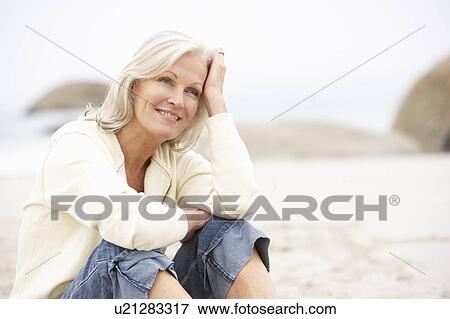 Senior Woman On Holiday Sitting On Winter Beach View Large Photo Image Stock Photo - Senior Woman On Holiday Sitting On Winter Beach. Fotosearch