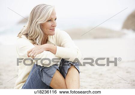 Senior Woman On Holiday Sitting On Winter Beach View Large Photo Image Stock Photograph - Senior Woman On Holiday Sitting On Winter Beach. Fotosearch