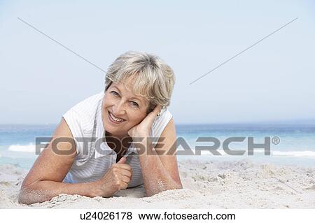 Senior Woman Relaxing On Sandy Beach View Large Photo Image Stock Photo - Senior Woman Relaxing On Sandy Beach. Fotosearch