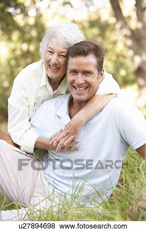 Stock Photo - Senior Woman With Adult Son In Garden. Fotosearch