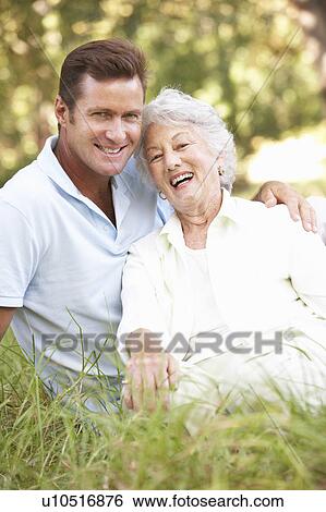 Stock Photograph - Senior Woman With Adult Son In Garden. Fotosearch