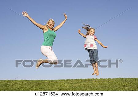 Senior woman with granddaughter jumping in air View Large Photo Image Picture - Senior woman with granddaughter jumping in air. Fotosearch