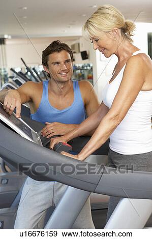 Stock Photo - Senior Woman Working With Personal Trainer On Running Machine In Gym. Fotosearch