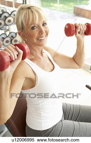 Stock Photography - Senior Woman Working With Weights In Gym. Fotosearch