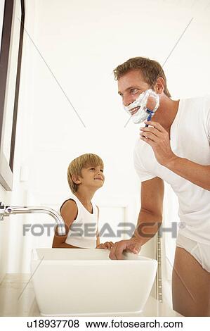Stock Photo - Son Watching Father Shaving In Bathroom Mirror. Fotosearch