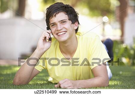 Teenage Boy Laying In Park Using Mobile Phone View Large Photo Image Stock Photo - Teenage Boy Laying In Park Using Mobile Phone. Fotosearch