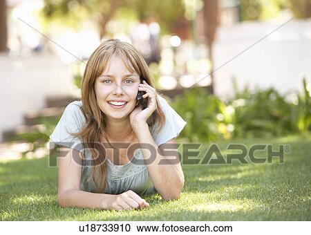 Teenage Girl Laying In Park Using Mobile Phone View Large Photo Image Stock Image - Teenage Girl Laying In Park Using Mobile Phone. Fotosearch