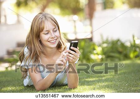 Teenage Girl Laying In Park Using Mobile Phone View Large Photo Image Stock Photo - Teenage Girl Laying In Park Using Mobile Phone. Fotosearch