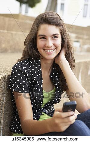 Teenage Student Sitting Outside On College Steps Using Mobile Phone View Large Photo Image Stock Photograph - Teenage Student Sitting Outside On College Steps Using Mobile Phone. Fotosearch