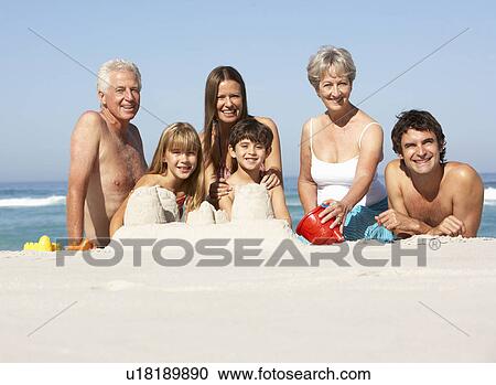 Three Generation Family Building Sandcastles On Beach Holiday View Large Photo Image Stock Image - Three Generation Family Building Sandcastles On Beach Holiday. Fotosearch