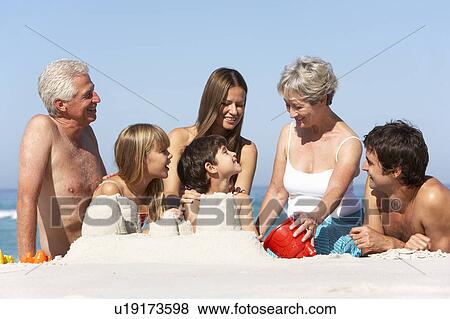 Three Generation Family Building Sandcastles On Beach Holiday View Large Photo Image Stock Photo - Three Generation Family Building Sandcastles On Beach Holiday. Fotosearch