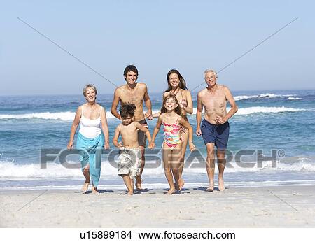 Three Generation Family On Holiday Walking Along Beach View Large Photo Image Picture - Three Generation Family On Holiday Walking Along Beach. Fotosearch