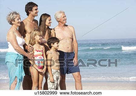 Stock Photo - Three Generation Family On Holiday Walking Along Beach. Fotosearch