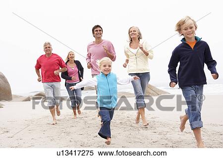 Stock Photography - Three Generation Family Running Along Winter Beach Together. Fotosearch