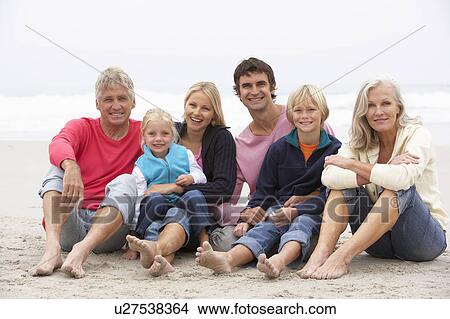 Picture - Three Generation Family Sitting On Winter Beach Together. Fotosearch